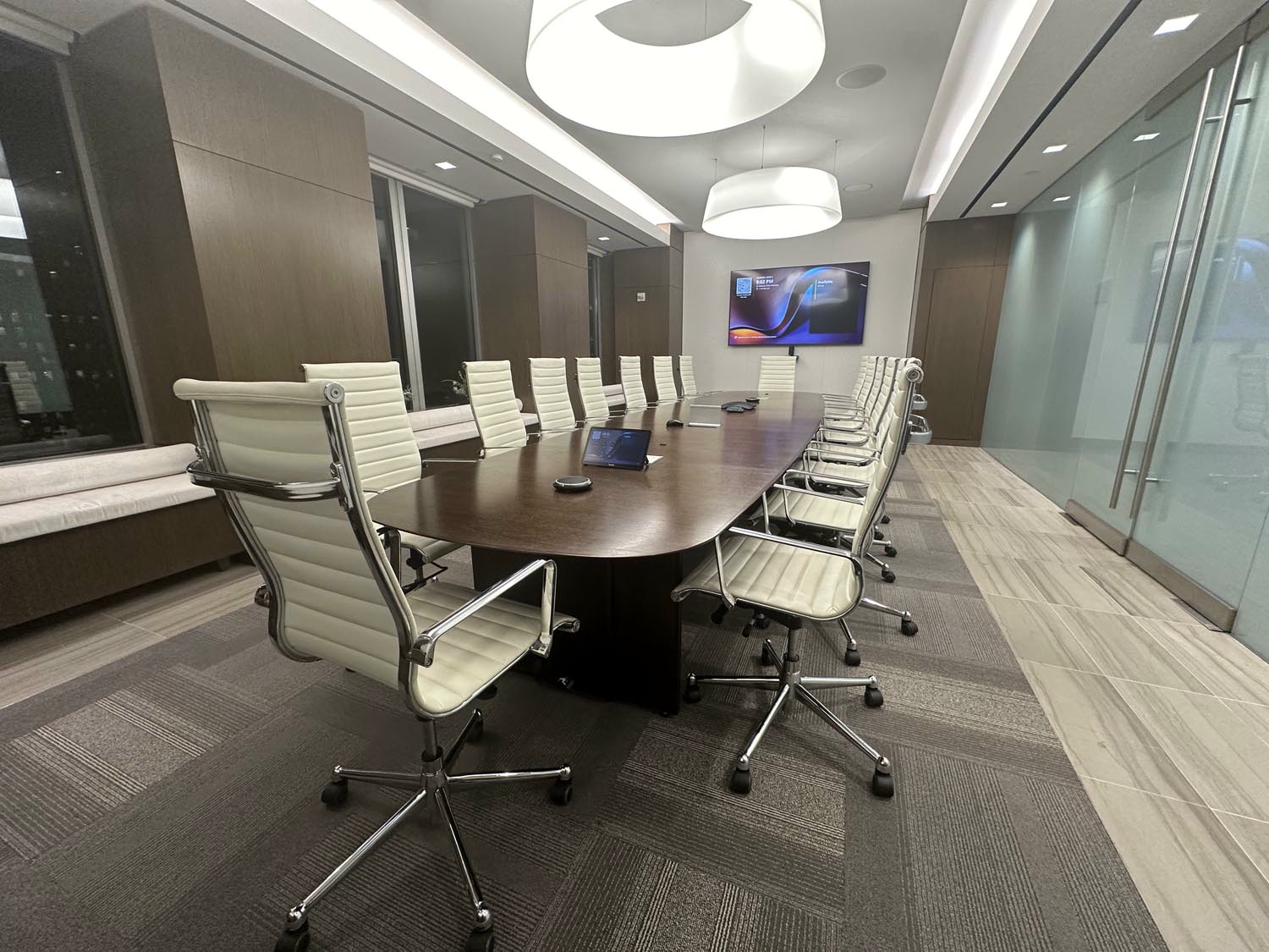 Law firm executive boardroom with dual displays and Crestron control